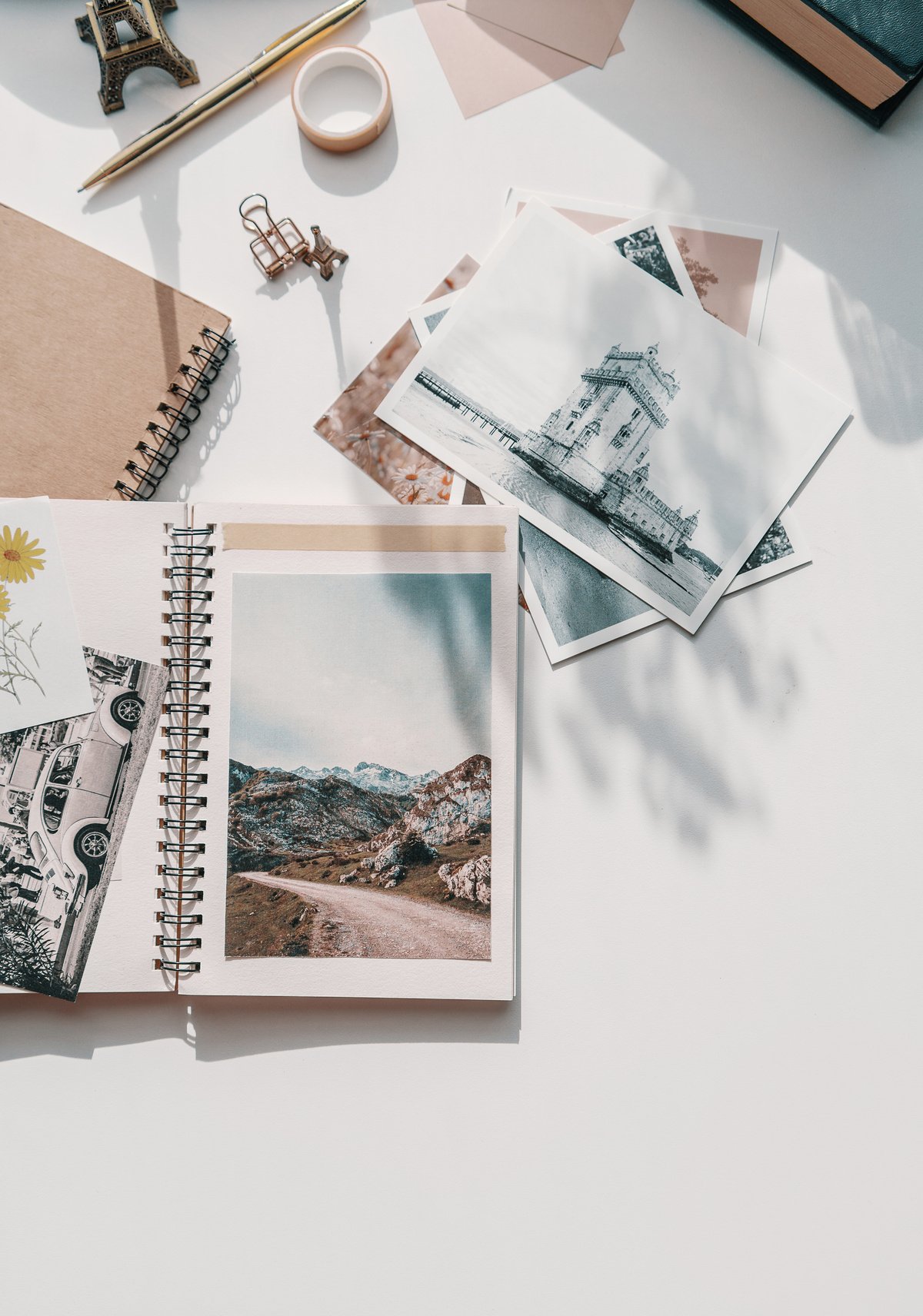 Travel journaling themed desk, printed photos, notebooks, aesthetic background